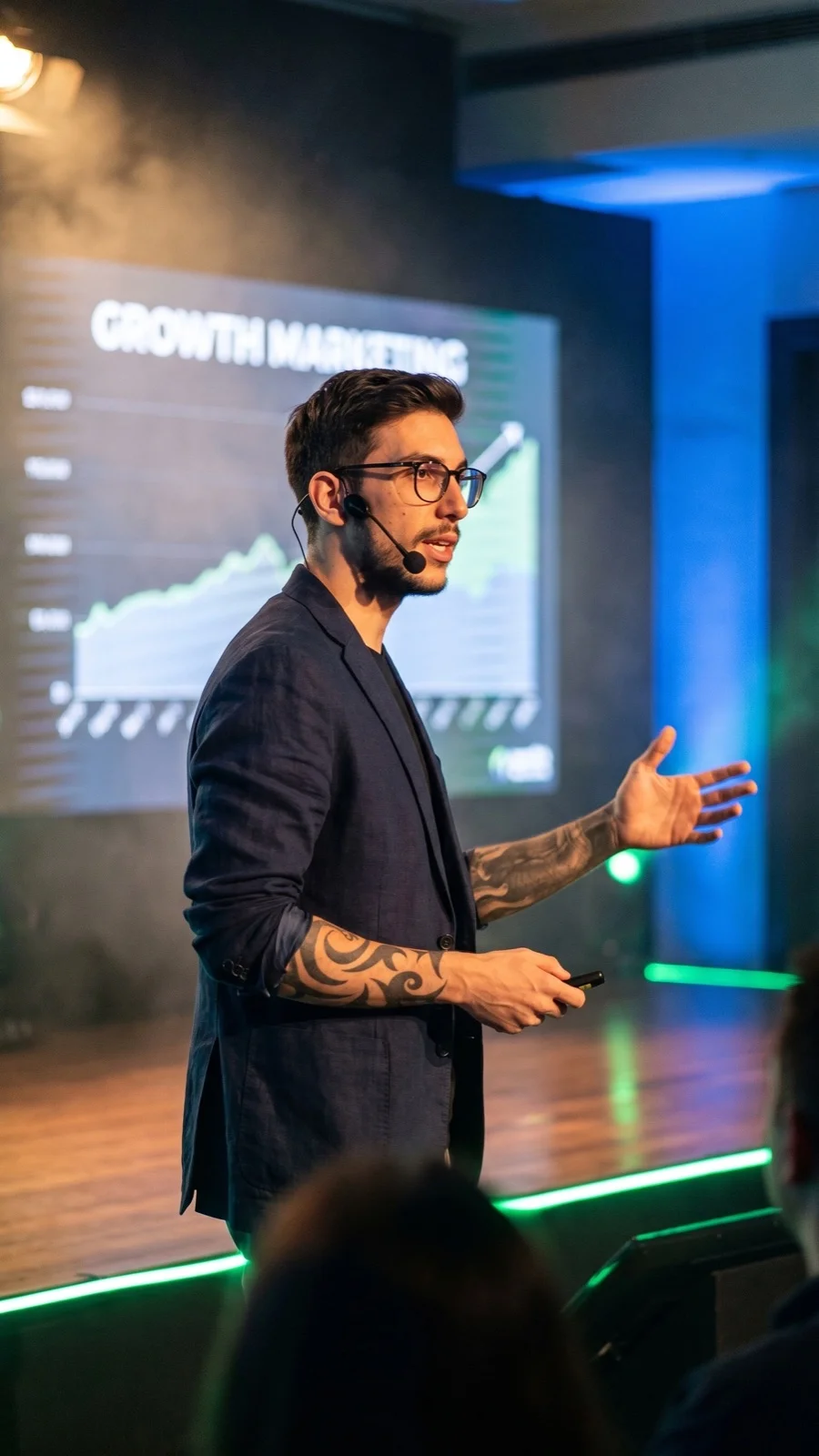 Matteo Coloru on stage durante keynote Growth Marketing con LED green dietro - cambiamo il mondo una KPI alla volta